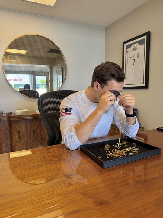 Examining a gold chain through a jeweler's loupe