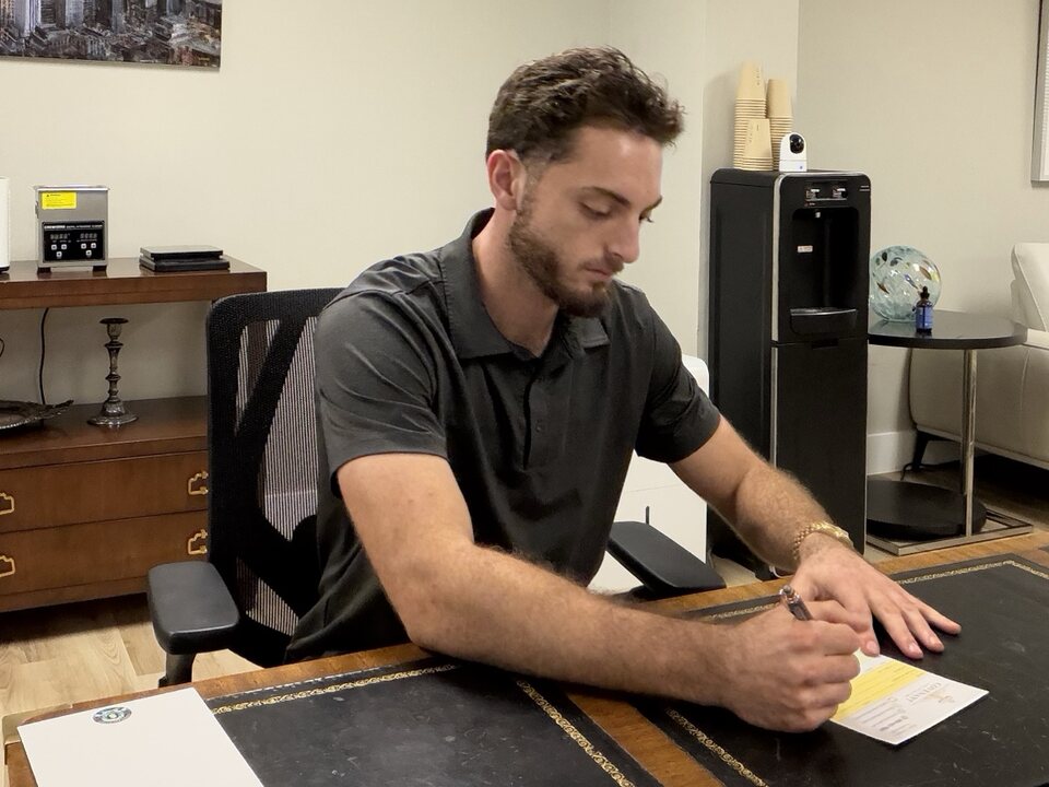 Josiah completing paperwork at a desk in the Covenant office
